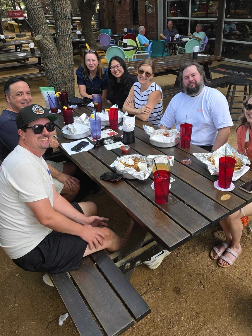 The team round a long table outdoors